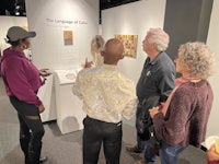 a group of people looking at art in a museum